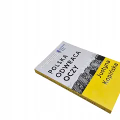 Książka "Polska odwraca oczy" Justyny Kopińskiej, nagrodzona European Press Prize. Okładka z napisem i zdjęciem budynków.