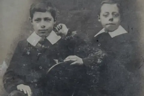 Dwaj chłopcy w strojach z epoki, być może młodzi adam mickiewicz dzieci, pozują do portretu.