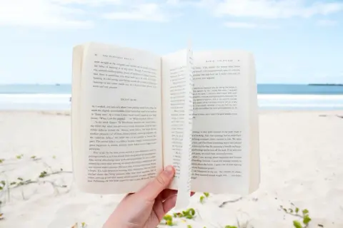 Otwarta książka na plaży, idealna lekka książka na wakacje.
